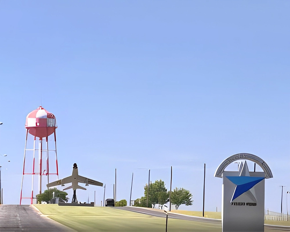 A view of an airport with a plane and a water tower.