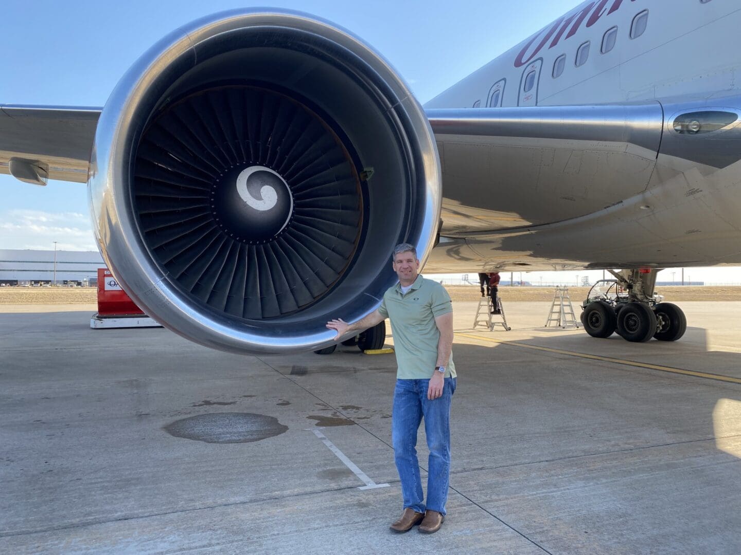 A man standing in front of an airplane engine.