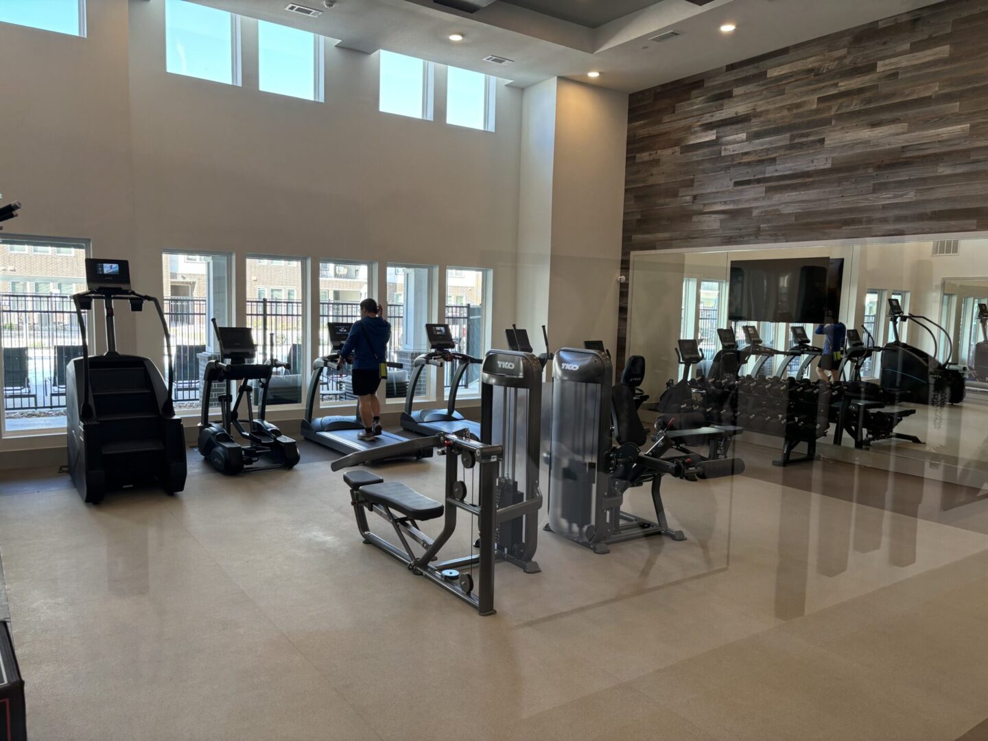 A gym with many machines and people in it