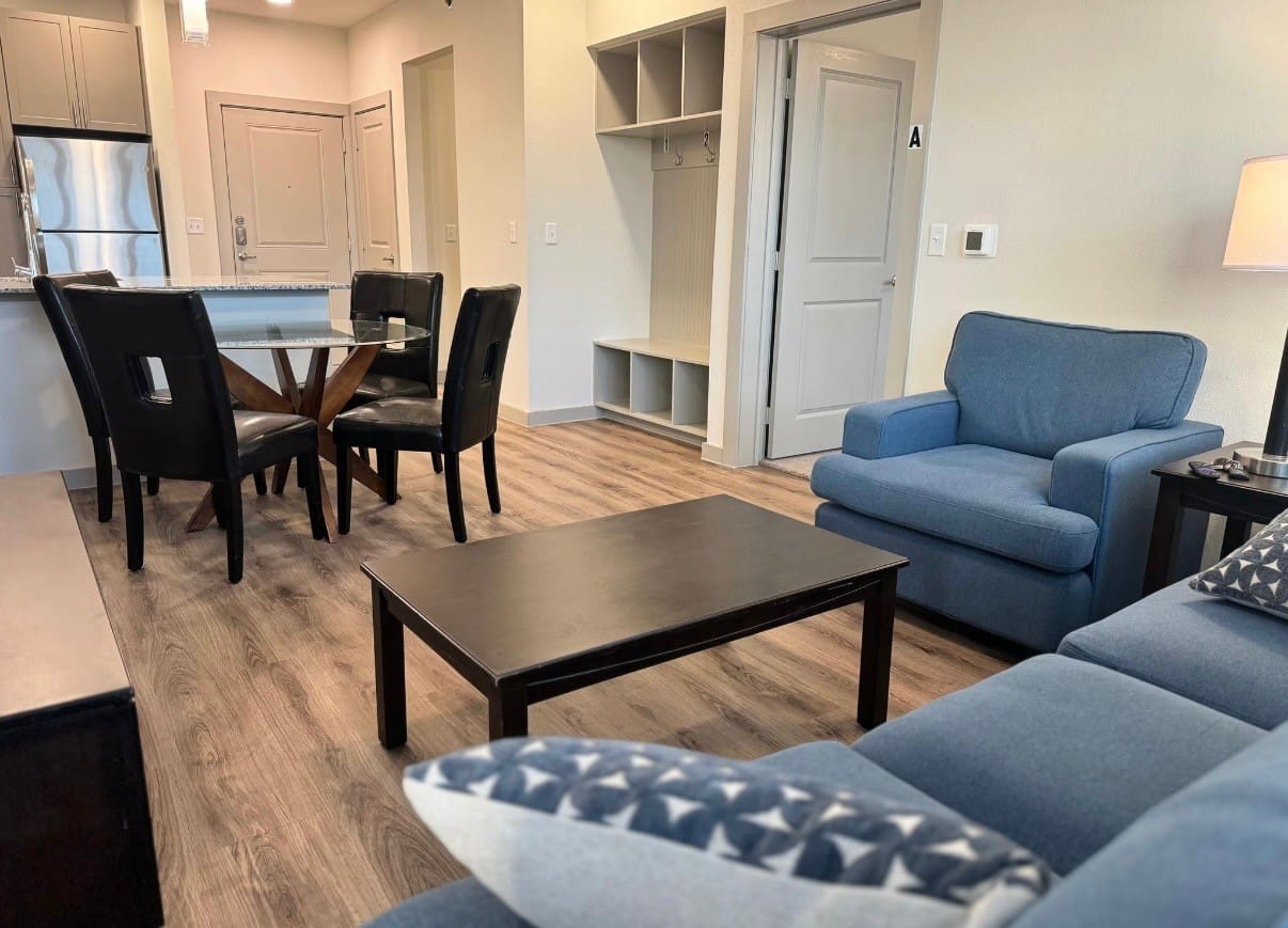 A living room with blue furniture and wooden floors.