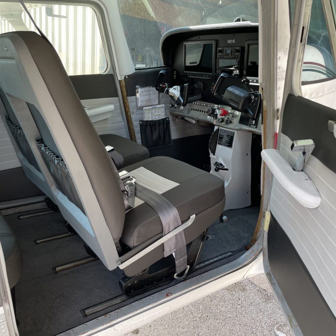 A car with the seats folded down and the door open.